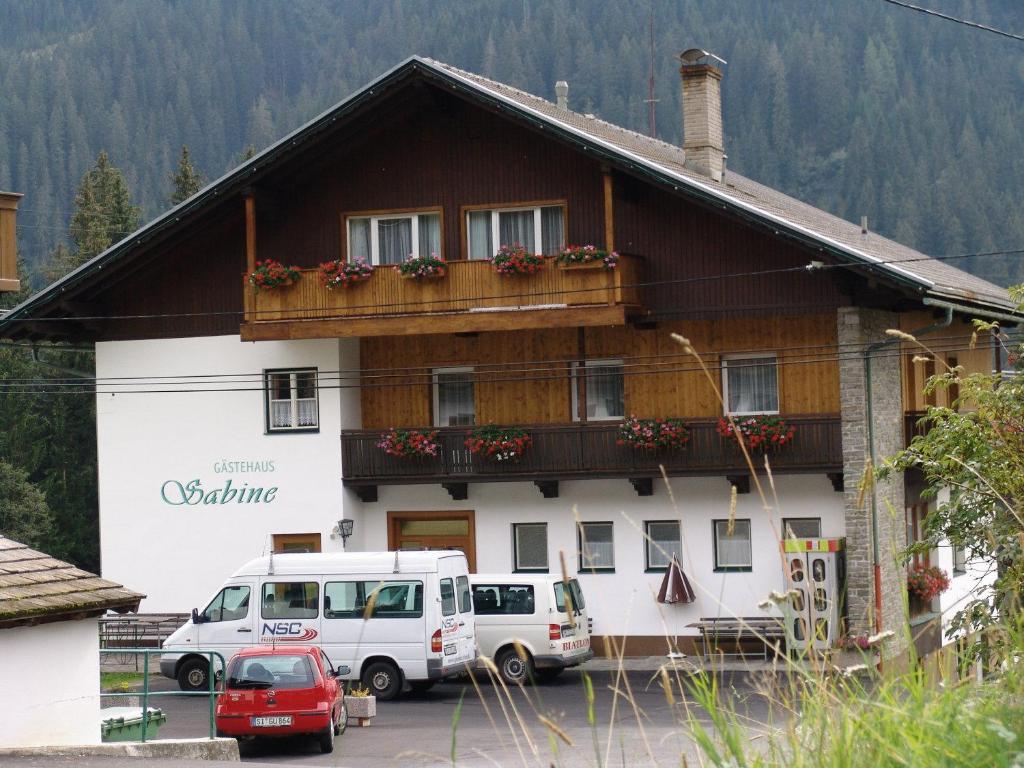 a building with cars parked in front of it at Appartementhaus Sabine in Obertilliach