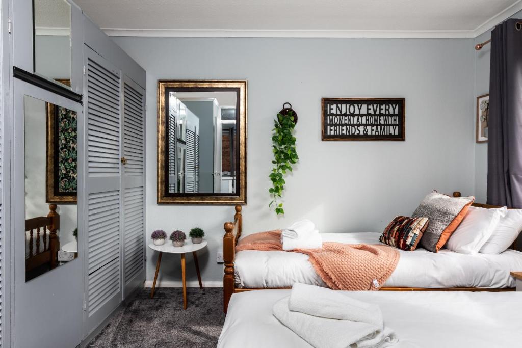 a bedroom with two beds and a mirror at Perfect for Contractors - Canterbury - Free parking - Ultra WiFi in Canterbury