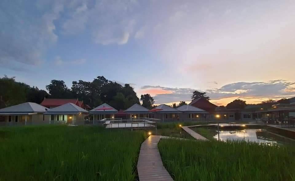a view of a resort with a pond and grass at Jeerang Countryside Resort in Mae Hong Son