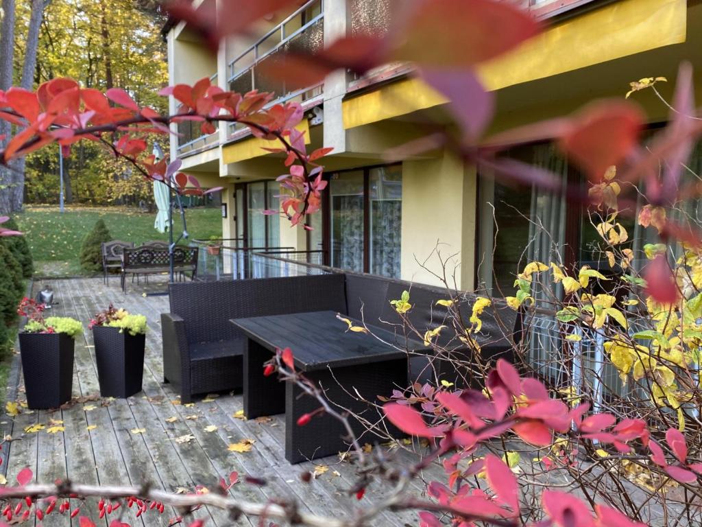 a black bench in front of a house at Kalnas II apartaments in Juodkrantė