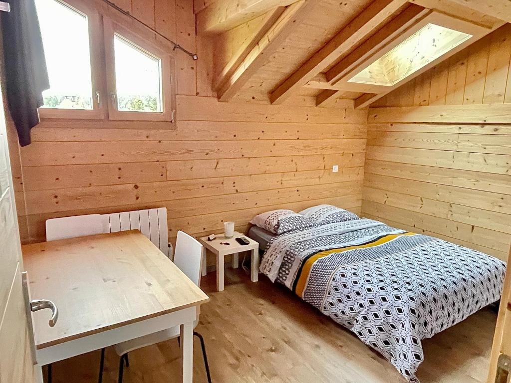 ein Schlafzimmer mit einem Bett in einer Holzhütte in der Unterkunft Chambre privée au pied des pistes - Chambre chez l'habitant - ChaletNelda com in Lamoura