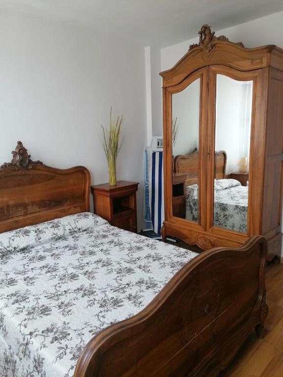 - une chambre avec un lit en bois et un miroir dans l'établissement Dadla, à Marseille