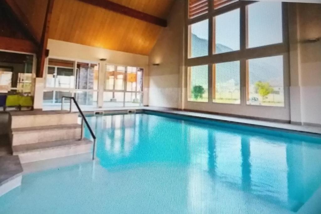 a swimming pool with blue water in a house at Le Belvédère in Saint-Mamet