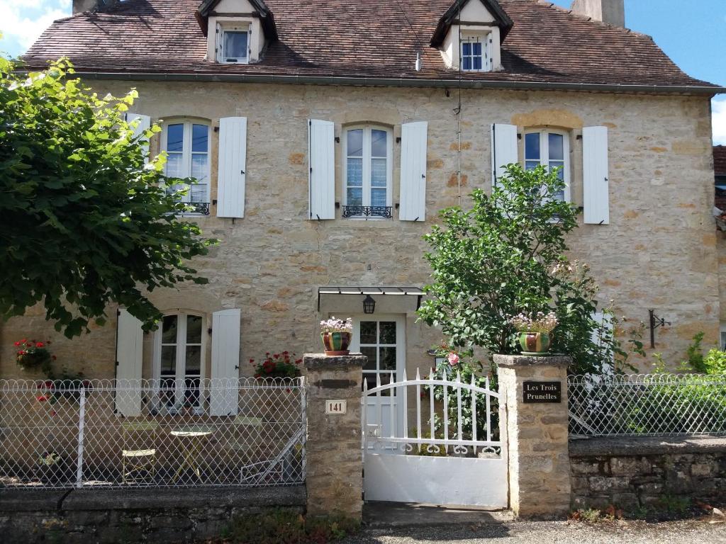 une vieille maison avec un portail et une clôture dans l'établissement Les Trois Prunelles, à Saint-Pierre-Toirac
