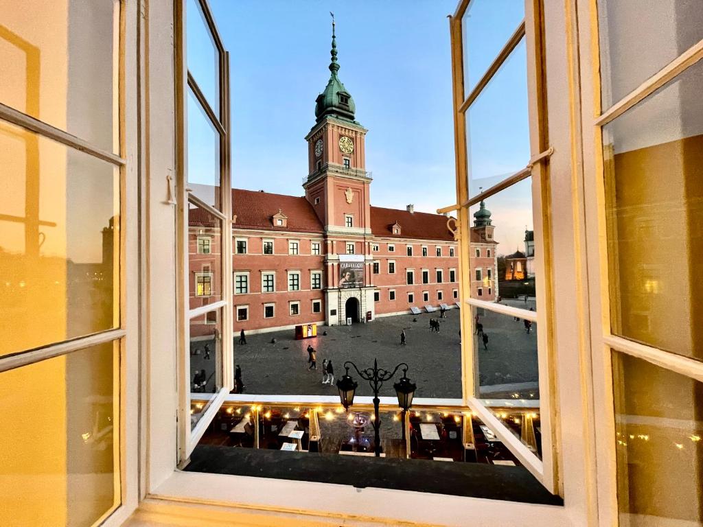 uma vista a partir de uma janela de um edifício com uma torre de relógio em ROYAL 2 Old Town fast WiFi Netflix HBO AppleTV+ em Varsóvia