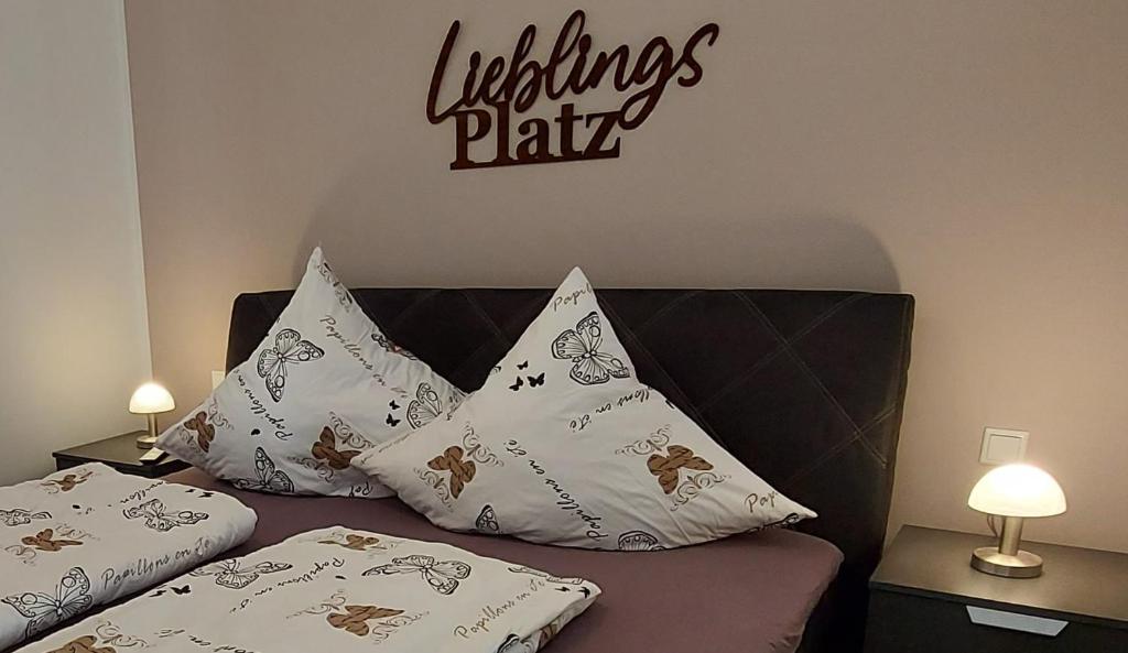 a bed with pillows on it with a sign on the wall at Moderne Ferienwohnung in Höxter an der Weser in Höxter