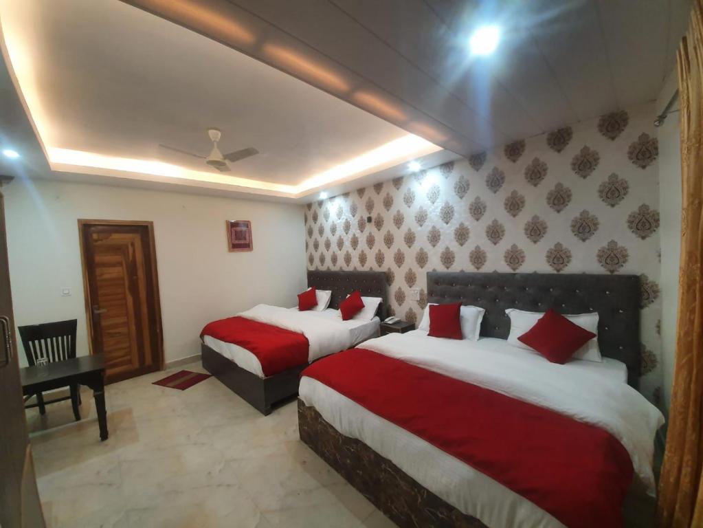 Baakhli Guest House and restaurant في Bhowāli: غرفة فندق بسريرين ومخدات حمراء
