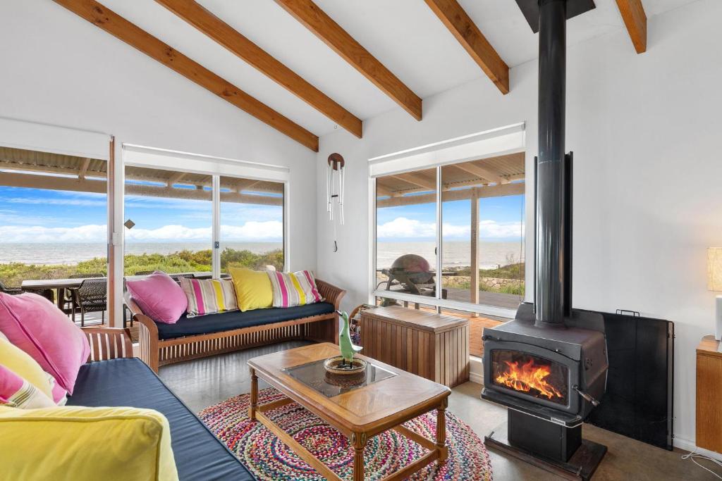 a living room with a fireplace and a couch at Bay Beach House - A Family & Pet Friendly Favourite with Direct Beach Access in Capel