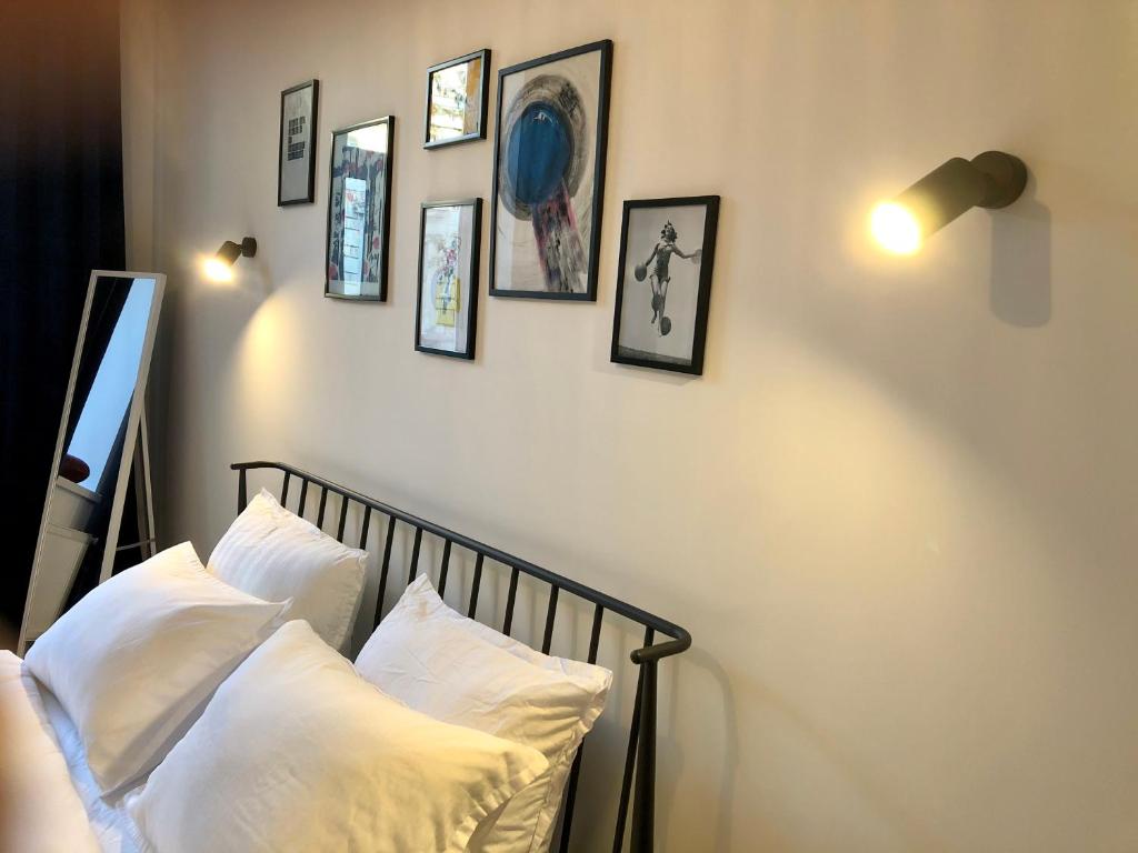 a bedroom with white pillows and pictures on the wall at Park apartment in the heart of the city in Lviv