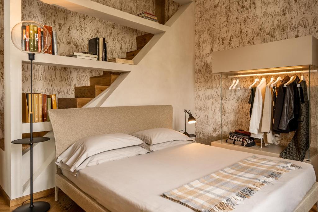 Oltrarno 1881 Apartments في فلورنسا: غرفة نوم بسرير كبير ودرج