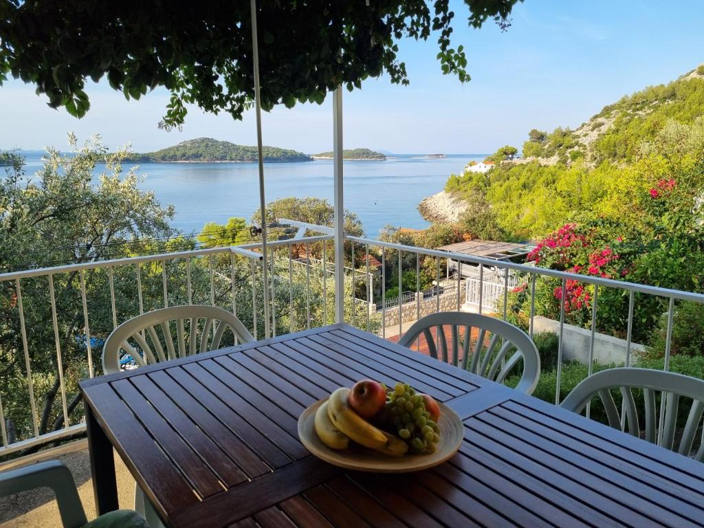 een bord eten op een tafel met uitzicht op de oceaan bij Holiday Home Prišćapac in Prizba