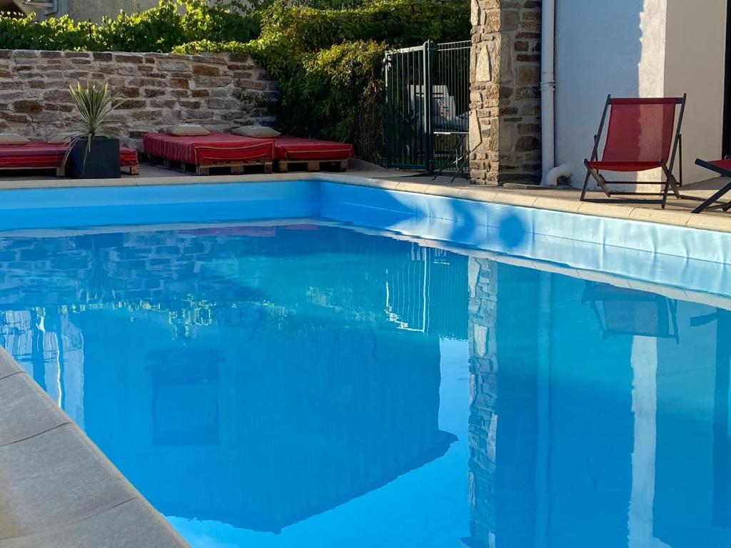 a swimming pool with blue water in a yard at MAISON MIGNARDISE - Cité in Carcassonne
