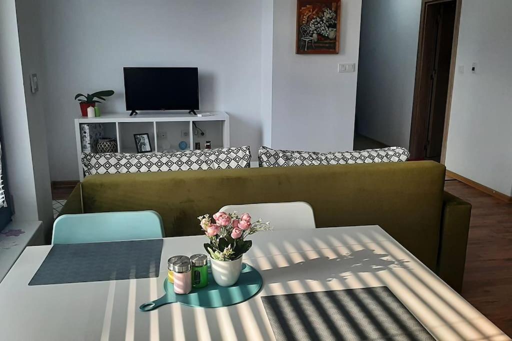 un salon avec une table avec des fleurs dessus dans l'établissement Rowing Base Apartment, à Plovdiv