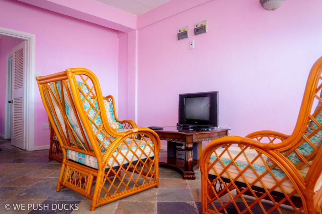 un soggiorno con 2 sedie e una TV di Belle View Apartment Villa - La Mar penthouse a Laborie