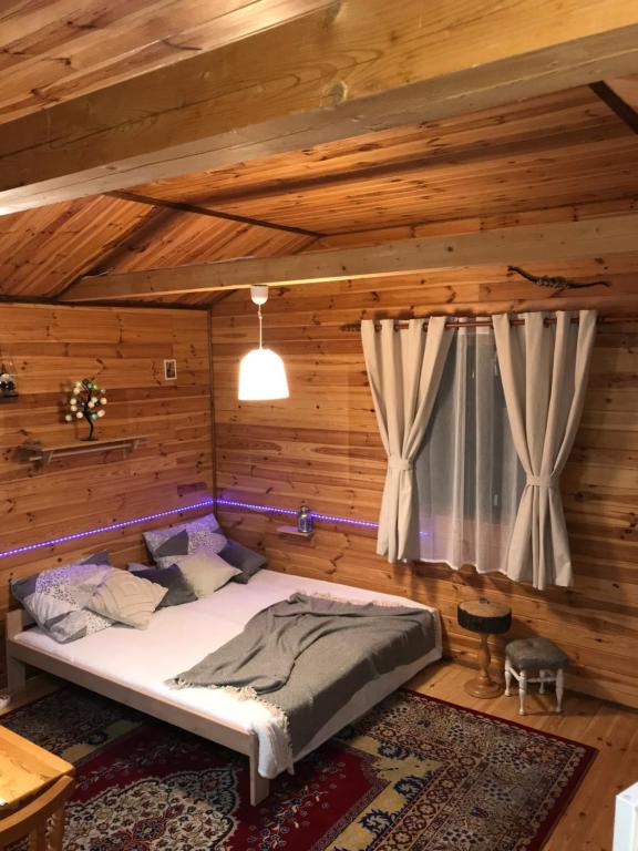 ein Schlafzimmer mit einem Bett in einem Blockhaus in der Unterkunft U Stefanów in Królowy Most