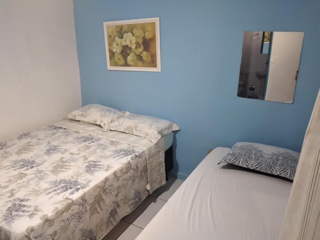 1 dormitorio con 2 camas y espejo en la pared en Dormitorios Rosario en Pirenópolis