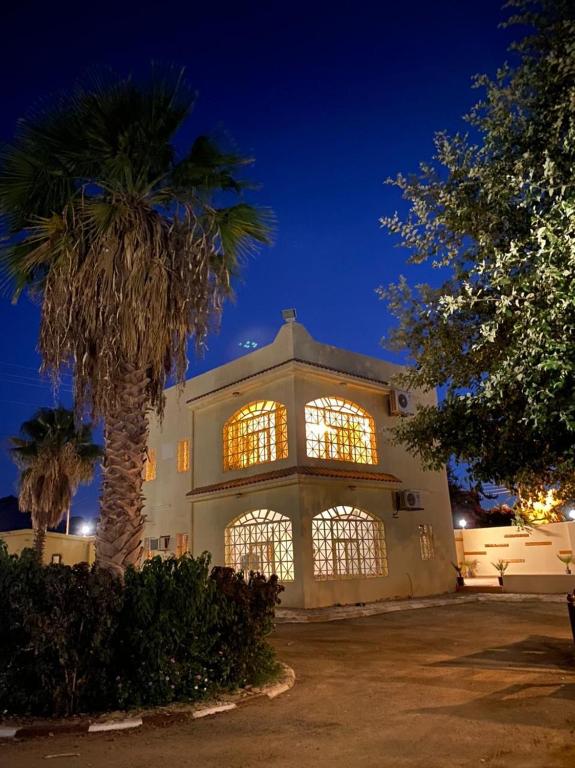 a building with a palm tree in front of it at فيلا آفيري Aviary villa in AlUla