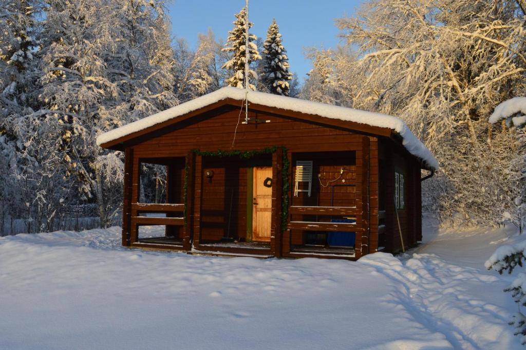 a wooden cabin in the snow with snow covered trees at Stuga i Pålles Stugby in Duved