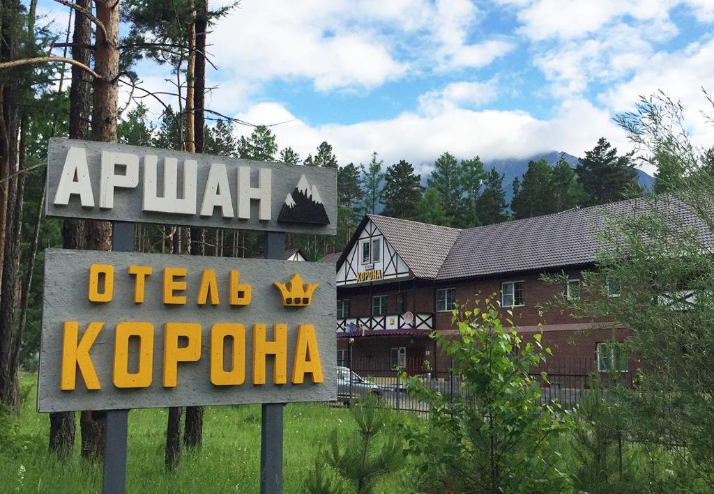 a sign in front of a house with a hotel at Отель Корона Аршана in Arshan