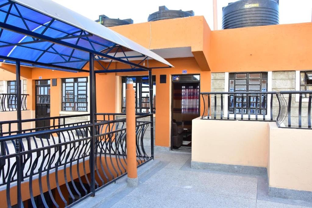 Athi River的住宿－Amber Apartments G2 Kitengela，一座橙色的建筑,拥有蓝色的屋顶和一个阳台