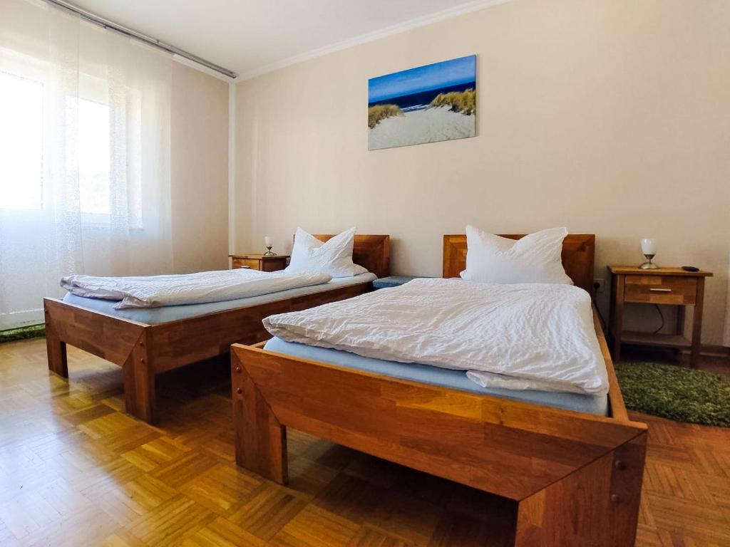 two twin beds in a room with wooden floors at Modern Apartment Wissenbach 1 in Eschenburg
