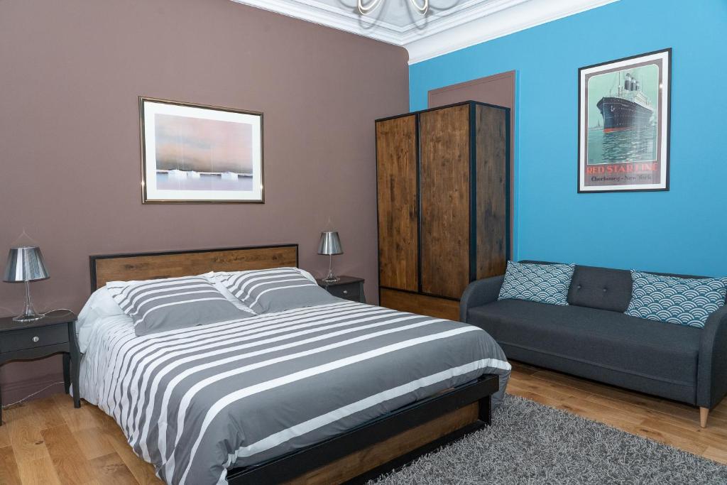 ein Schlafzimmer mit einem großen Bett und einem Sofa in der Unterkunft Demeure Belle Epoque in Reims