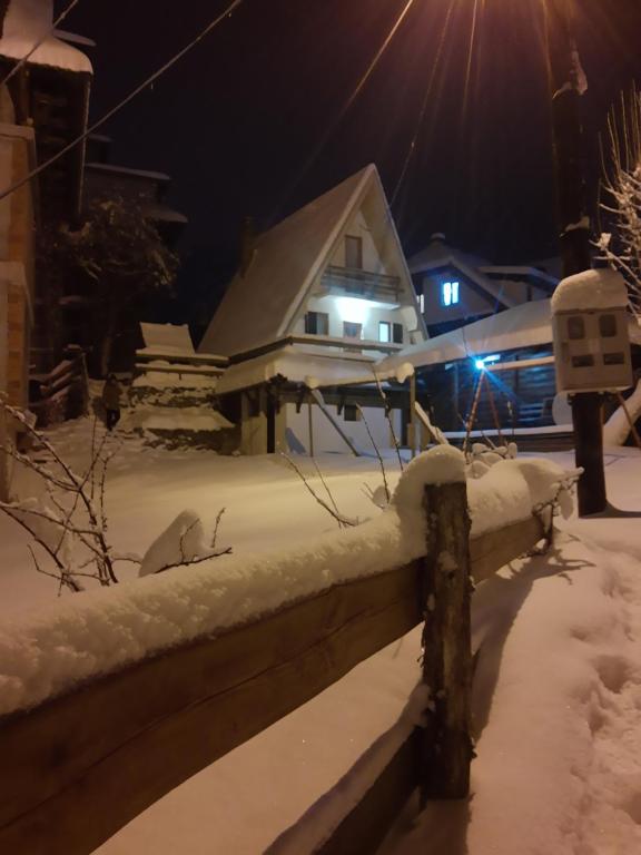ein Haus ist nachts mit Schnee bedeckt in der Unterkunft Vikend kuca Bela Reka in Brzeće