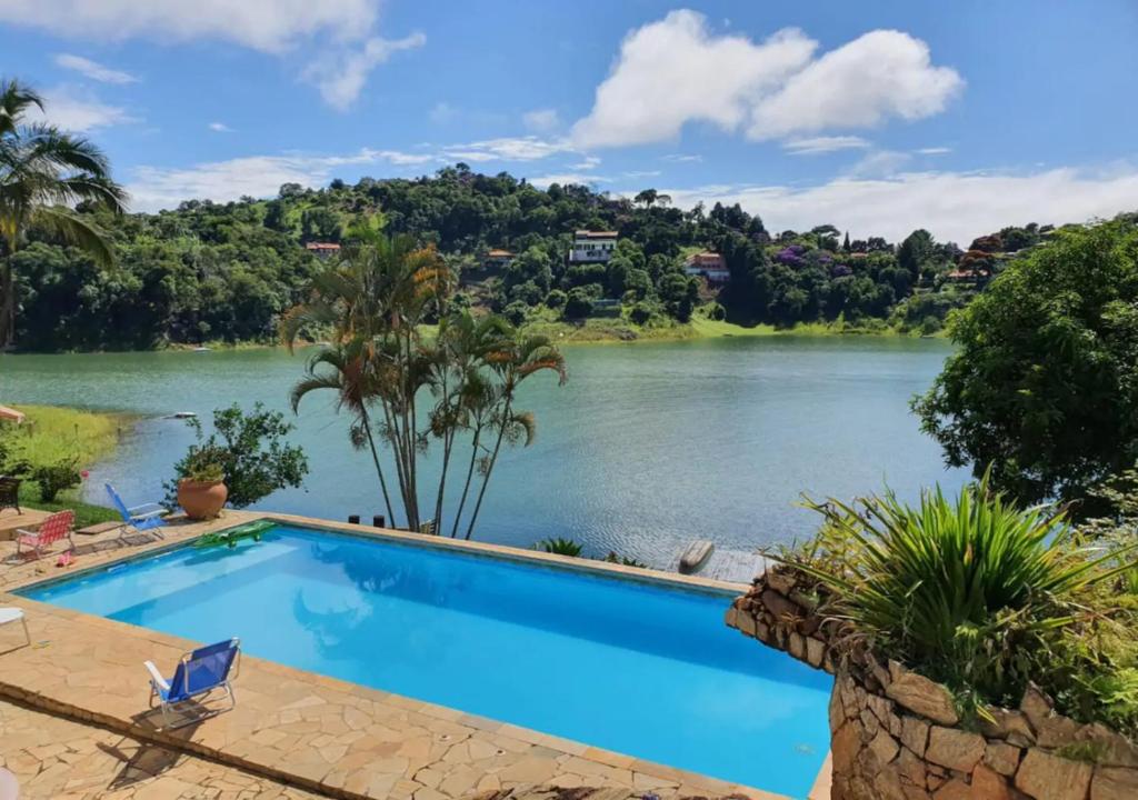 a swimming pool with a view of a river at MARAVILHOSO SÍTIO NA BEIRA DA REPRESA in Igaratá