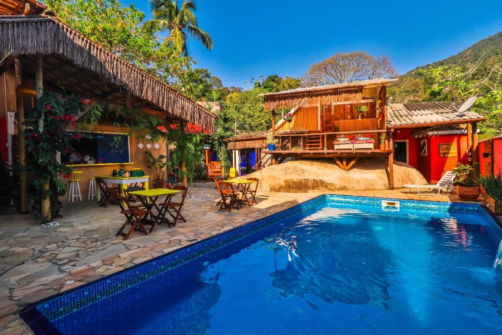 a swimming pool in front of a house at La Gloria House in Ilhabela