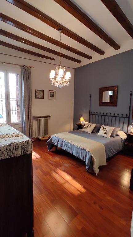 1 dormitorio con 2 camas y lámpara de araña en Casa MO en Sabadell