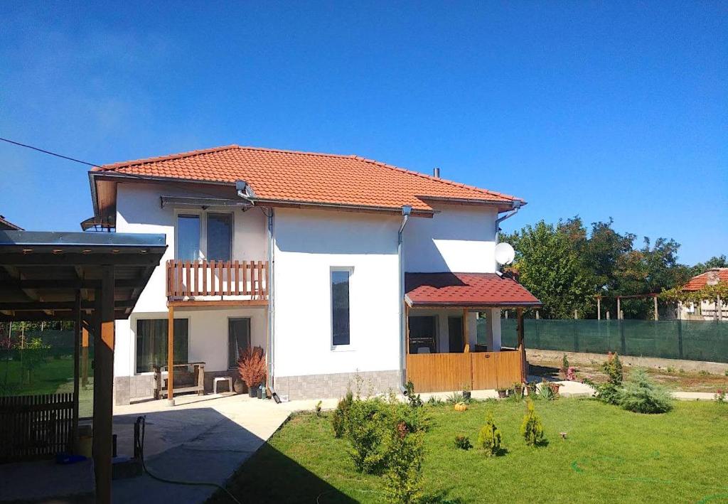 une maison blanche avec un toit rouge et une cour dans l'établissement Villa "Old Station", à Vetren Dol
