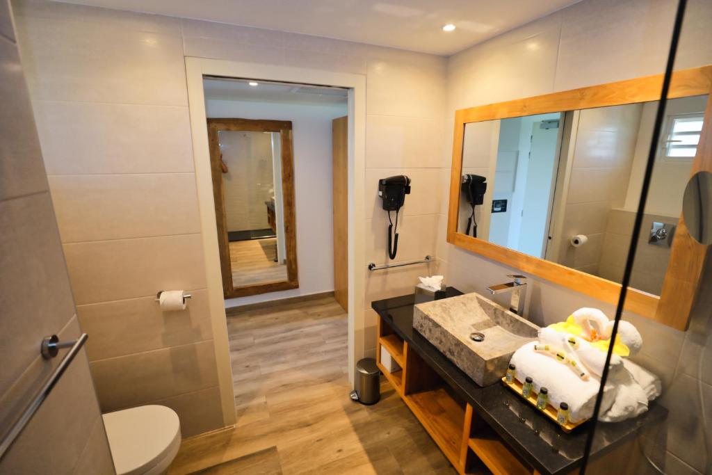 a bathroom with a sink and a mirror at Orient Beach Hotel in Orient Bay