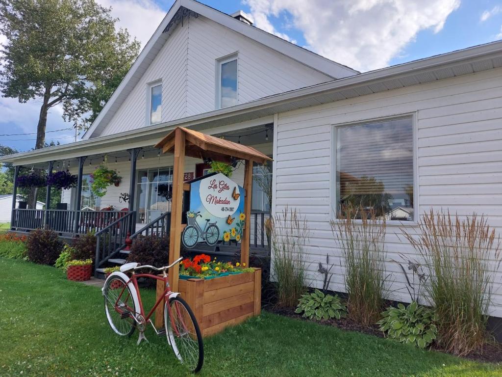 ein Fahrrad, das vor einem Haus geparkt ist in der Unterkunft Les Gites Makadan in Normandin