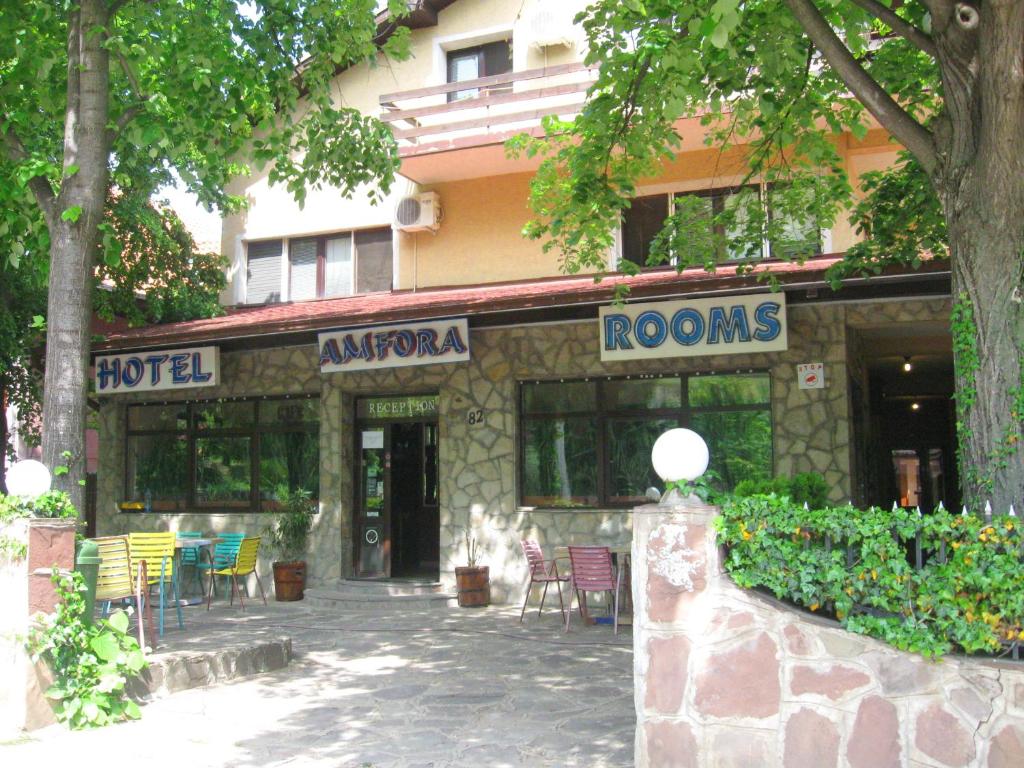 a building with tables and chairs outside of it at Amfora Rooms Caribrod in Dimitrovgrad