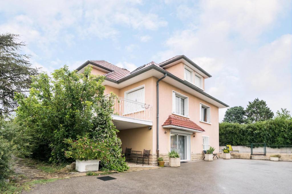 Une grande maison avec balcon est située dans une rue. dans l'établissement Appartement Indépendant en maison à 15 MIN de LYON, à Saint-Symphorien-dʼOzon