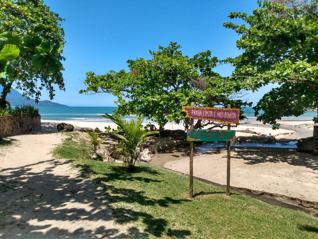 un cartel en una playa con el océano en el fondo en Casa aconchegante em Guaeca - 8 pessoas, en São Sebastião