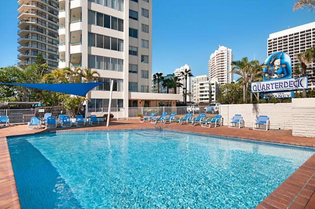 a large swimming pool with chairs and a building at Quarterdeck Apartments in Gold Coast