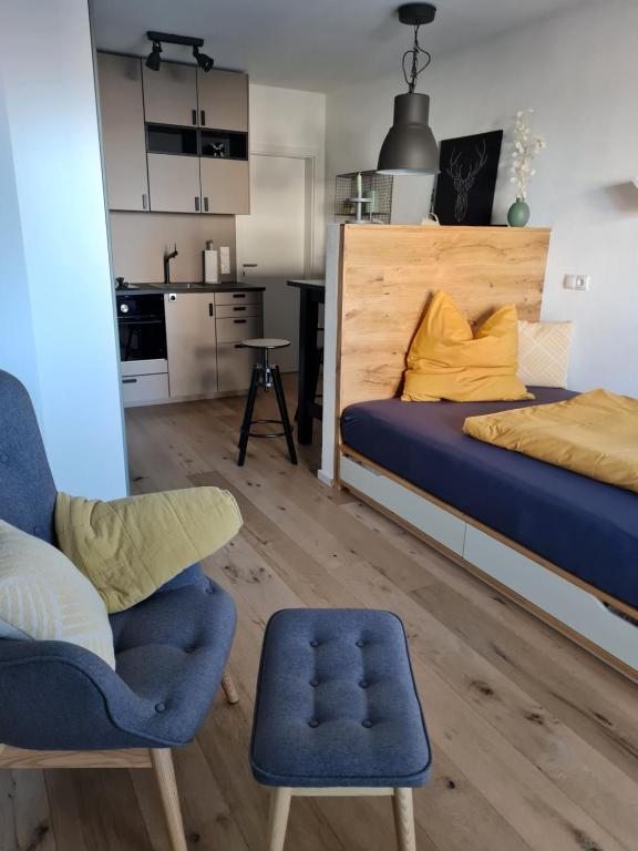 1 dormitorio con 1 cama y 1 silla en Moggele, en Scheidegg