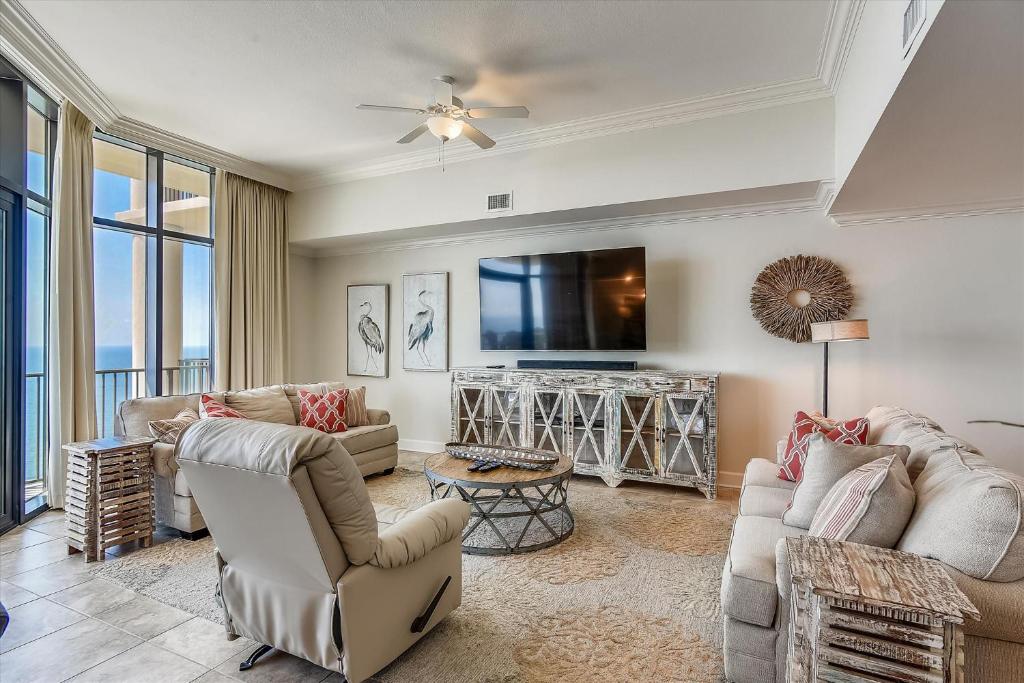 a living room with couches and a flat screen tv at The Oasis at Orange Beach Unit 3007 (formerly Phoenix West II) in Orange Beach