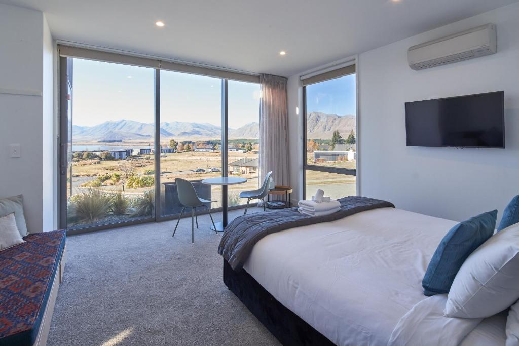 a bedroom with a bed and a view of the desert at Lakeview Studio B - Lake Tekapo in Lake Tekapo