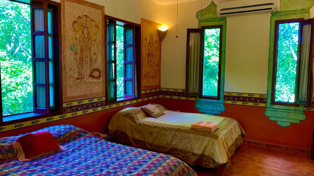 Postel nebo postele na pokoji v ubytování Gardenhotel Macan Ché B&B