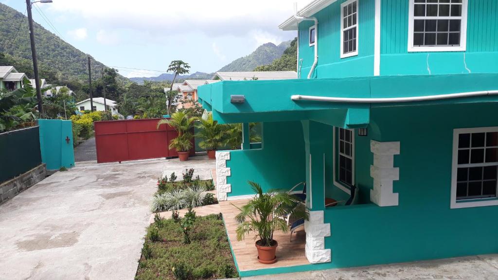 a blue house with a courtyard with plants at Amazon Villas in Soufrière