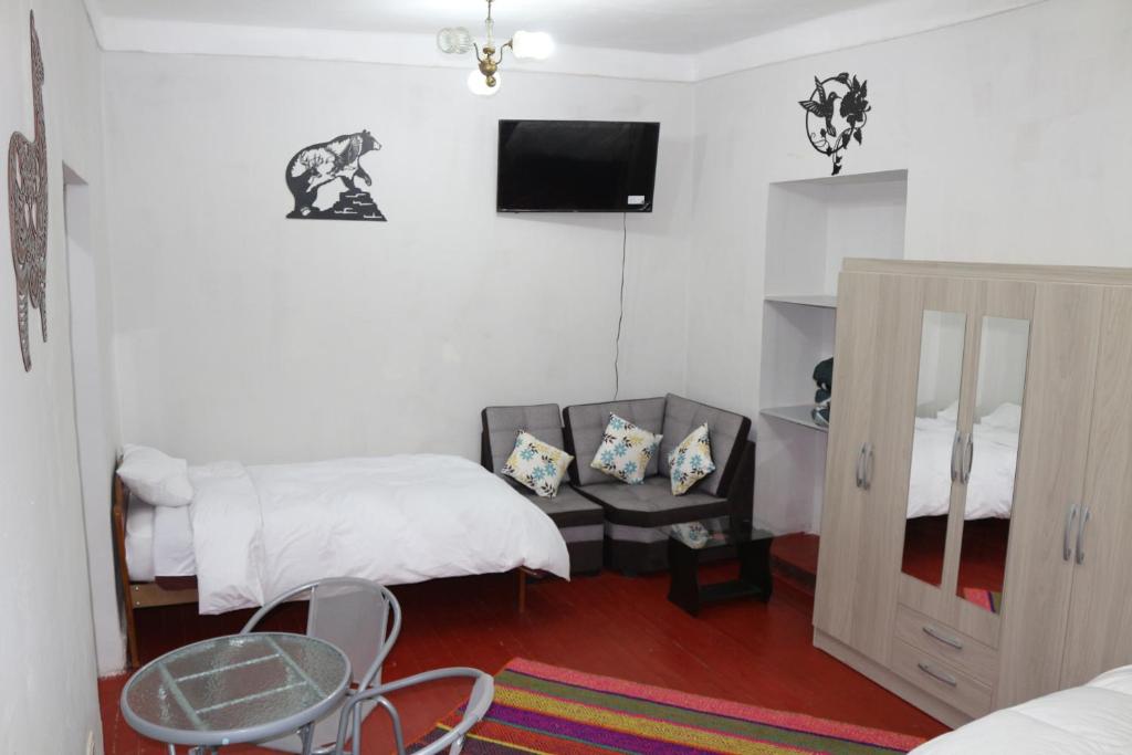a bedroom with a bed and a table and a tv at Apartamento Privado en Centro Histórico de Cusco in Cusco