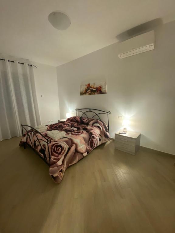 1 dormitorio con 1 cama y 1 mesa con lámpara en Fringiulì House en Trevignano Romano