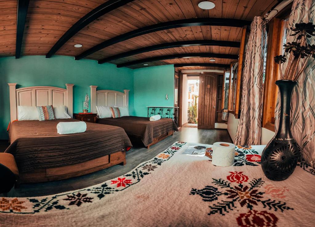 1 Schlafzimmer mit 2 Betten in einem Zimmer mit grünen Wänden in der Unterkunft Hostal Mago in Tlaxcala de Xicohténcatl
