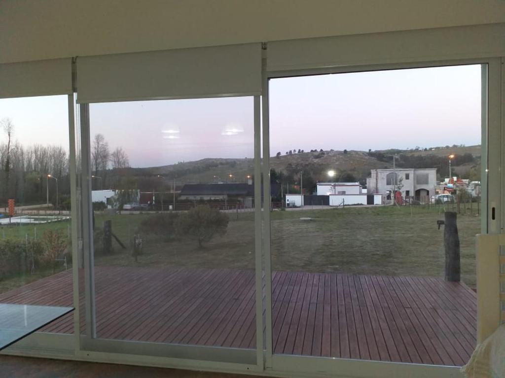 una puerta de cristal abierta con vistas a un campo en La paz en Tandil