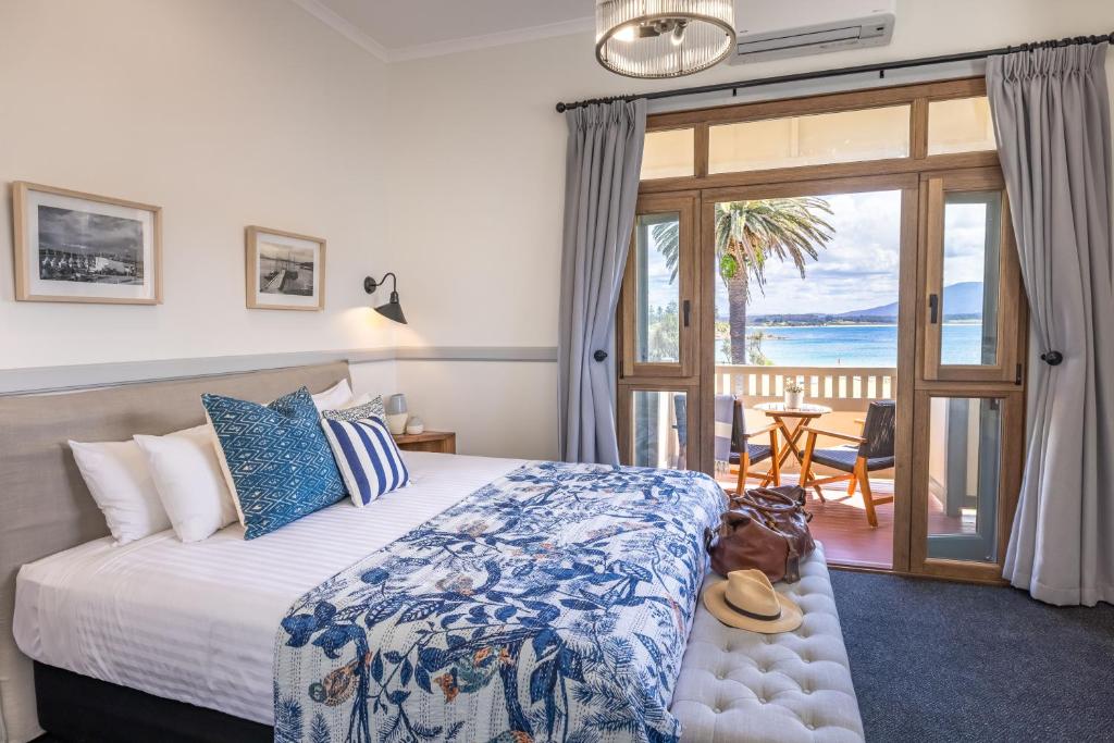 a bedroom with a bed with a view of the ocean at Bermagui Beach Hotel in Bermagui