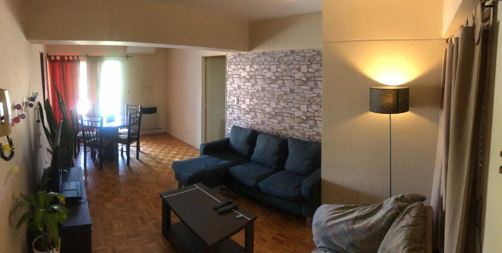 uma sala de estar com um sofá azul e uma mesa em Departamento Av. Colon (Ubicacion 9.8 puntos) em Mendoza