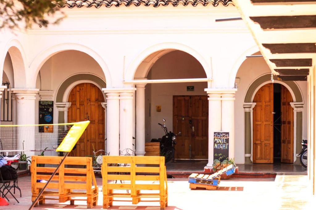 un grupo de sillas de madera frente a un edificio en Fandango en San Cristóbal de Las Casas
