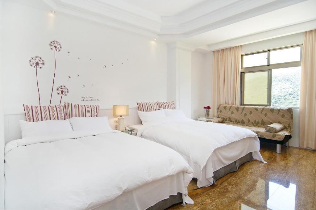 a white bedroom with two beds and a couch at Lutai B&B in Yung-an-ts'un